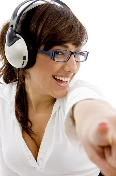 Χαμογελαστή γυναίκα δείχνει με ακουστικά — Φωτογραφία Αρχείου