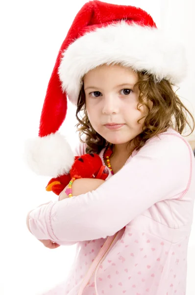 Kız onu oyuncak Noel Baba şapkası ile poz — Stok fotoğraf