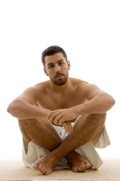 Muž v ručníku, sedí se zkříženýma nohama — Stock fotografie