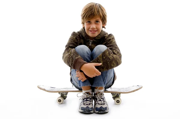Junge sitzt auf Skateboard — Stockfoto
