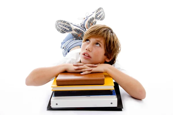 Kitaplar üzerinde oturan genç çocuk düşünme wile — Stok fotoğraf