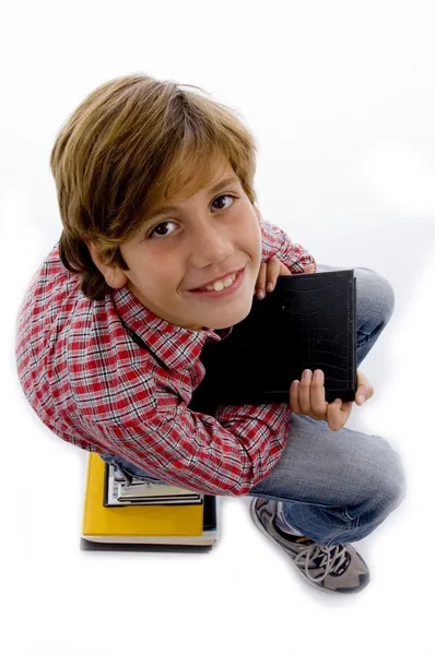 Pojken sitter på högen av böcker — Stockfoto