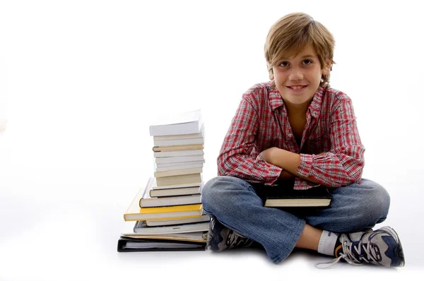 Jeune étudiant à côté d'une pile de livres — Photo