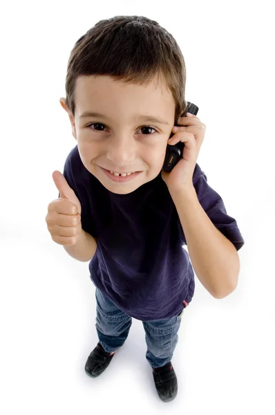 Дружній хлопчик зайнятий по телефону, великі пальці вгору — стокове фото