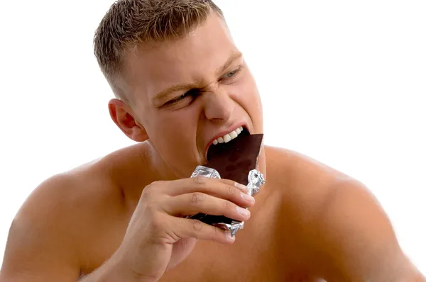 Muscular cara comer chocolate — Fotografia de Stock