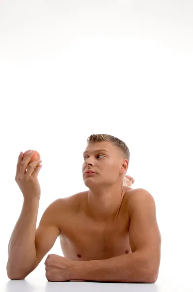 Muskulöser Mann schaut auf Apfel — Stockfoto