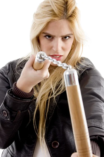 Агрессивная женщина держит нунчаку — стоковое фото
