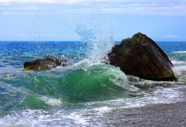 Waves, stone and sea foam