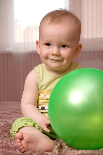 Pequeno bebê com bola verde — Fotografia de Stock