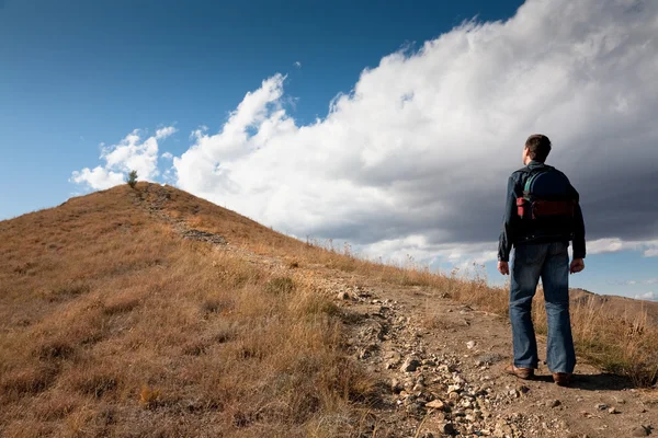 Homem olhando no pico da montanha — Fotografia de Stock