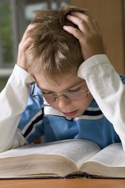 Boy is concentrated with reading clipart