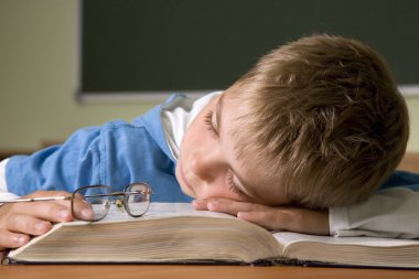 Boy has fallen asleep on book clipart