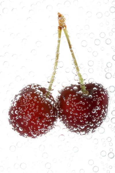 Cherry in water with bubbles — Stock Photo, Image