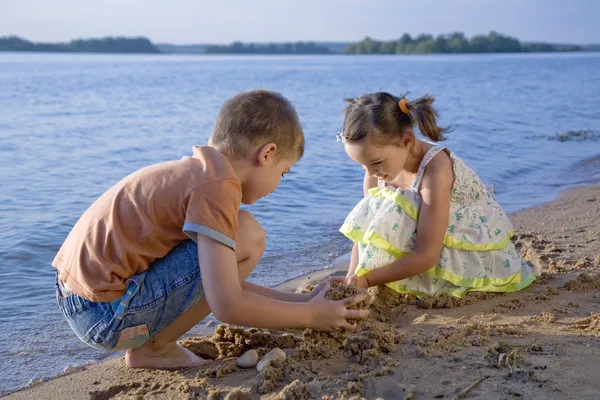 Мальчик и девочка играют в песок — стоковое фото