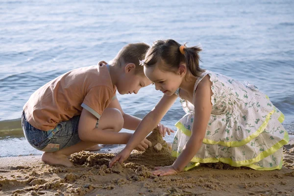 Мальчик и девочка играют в песок — стоковое фото