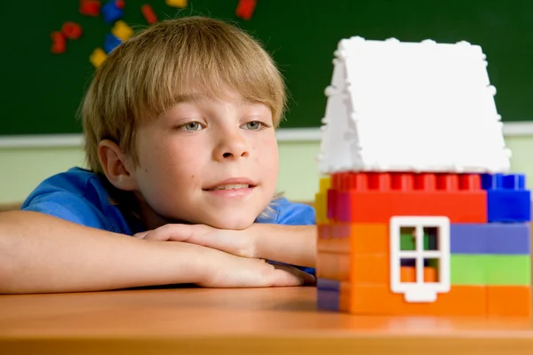 Хлопчик з маленьким іграшковим будинком — стокове фото