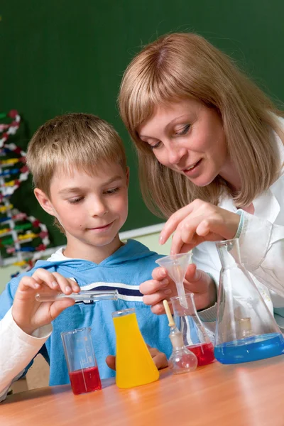 Мальчик и учитель, работающие с химикатами — стоковое фото