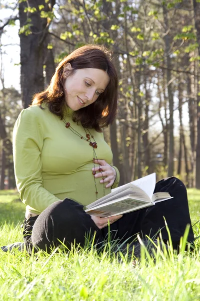 Kobieta w ciąży czyta — Zdjęcie stockowe
