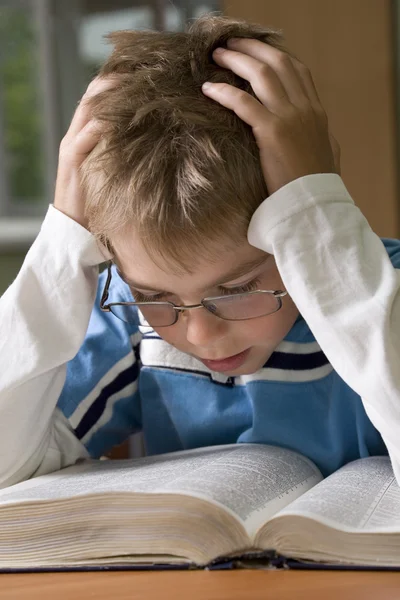 Boy se concentra con la lectura —  Fotos de Stock