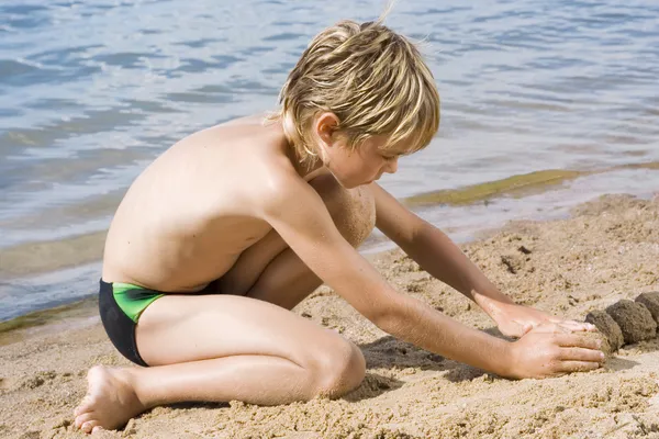 Bonito menino pequeno na areia — Fotografia de Stock