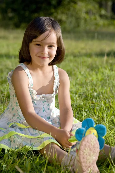 Yeşil çimlerin üzerinde sevimli küçük bir kız — Stok fotoğraf