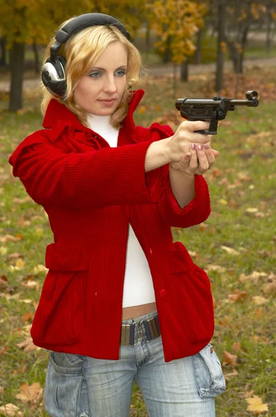 stock image Girl in headphones with pistol