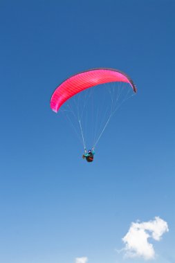 Parachutist in blue sky clipart