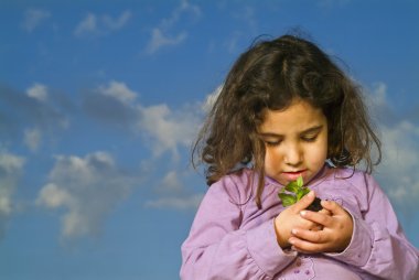 Littel girl holding plant clipart