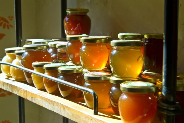Honey jars on a shelf — Stock Photo, Image