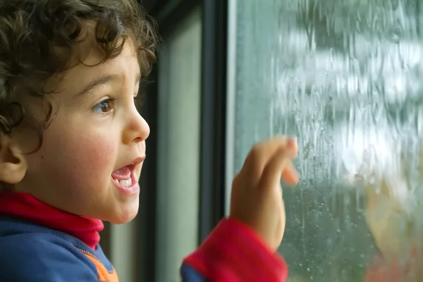 Kleiner Junge beobachtet den Regen — Stockfoto