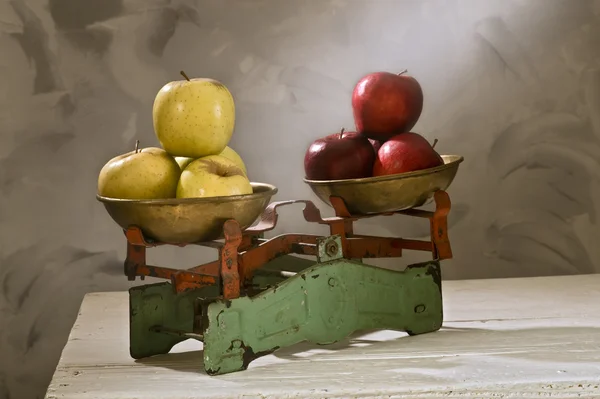 Oude weegschalen met gele en rode appels — Stockfoto