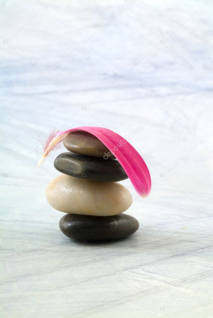 Balancing stones and pink petal