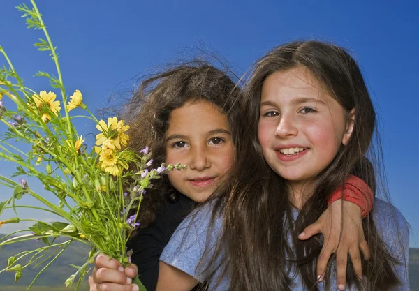 Två flickor och gula blommor — Stockfoto