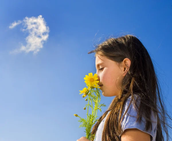 Joven chica oliendo flores — Foto de Stock