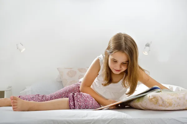 Menina lendo na cama — Fotografia de Stock