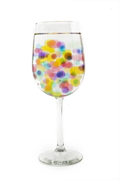 Bolas coloridas em um copo de vinho — Fotografia de Stock