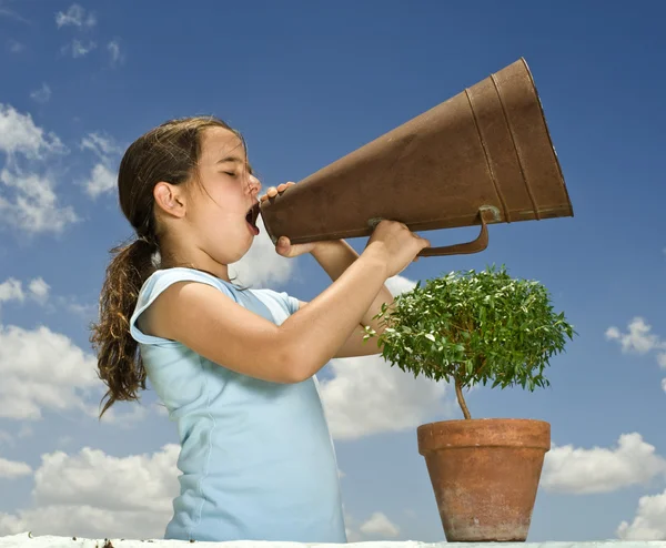 Meisje met megafoon en kleine boom — Stockfoto
