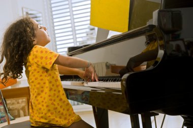 Little girl playing the piano clipart