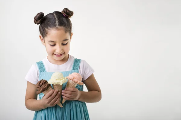 Petite fille tenant trois cônes de crème glacée — Photo