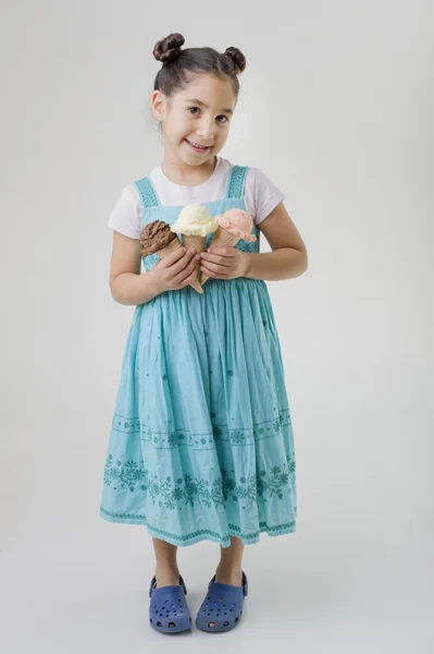 Маленькая девочка с тремя рожками мороженого — стоковое фото