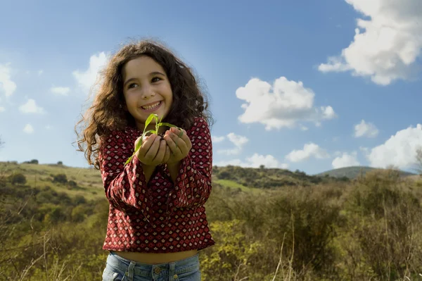 Küçük kız holding bitki — Stok fotoğraf