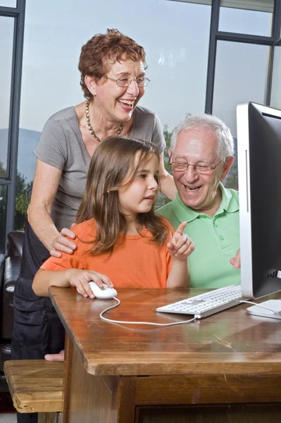 Grandparents and granddaughter with computer — Stock Photo, Image