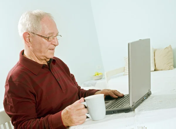 Старший чоловік з ноутбуком — стокове фото