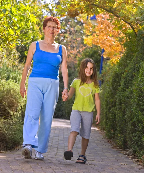 Seniorin geht mit Enkelkind spazieren — Stockfoto