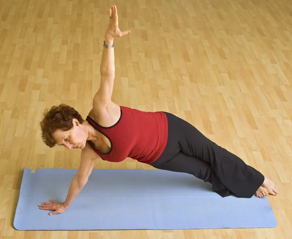 Senior woman exercising yoga — Stock Photo, Image
