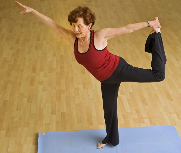 Mulher sênior exercitando ioga — Fotografia de Stock