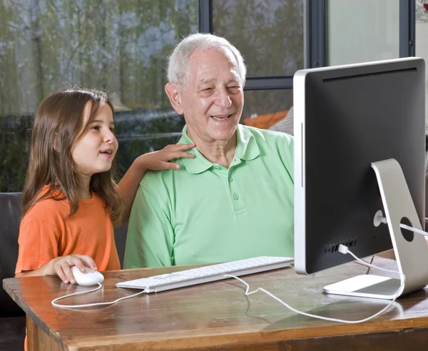 Grootvader en kleindochter met computer — Stockfoto