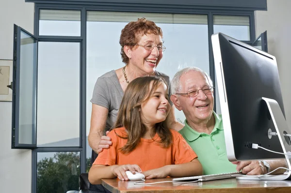 Abuelos y nieta con computadora —  Fotos de Stock