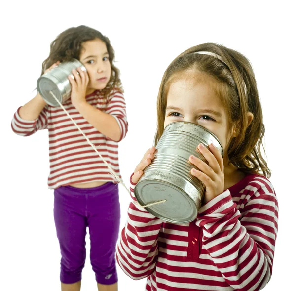 Twee meisjes praten over een tin telefoon — Stockfoto