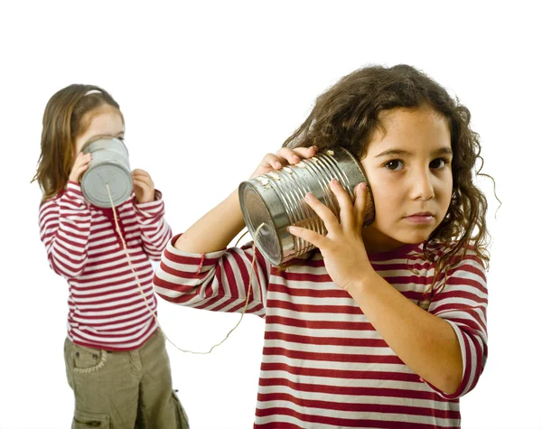 Twee meisjes praten over een tin telefoon — Stockfoto